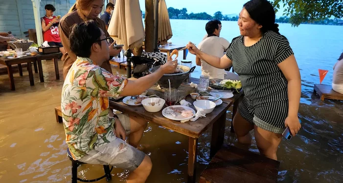 Flooded Thai restaurant becomes a hit with local diners, who dodge waves from passing boats while eating their meals